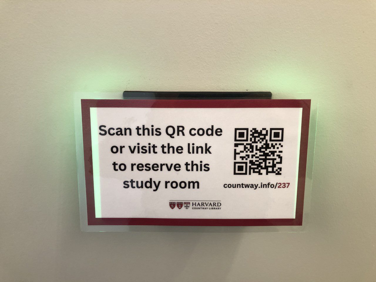 Sign with a URL and QR code for room reservation alongside the following text: Scan this QR code or visit the link to reserve this study room.