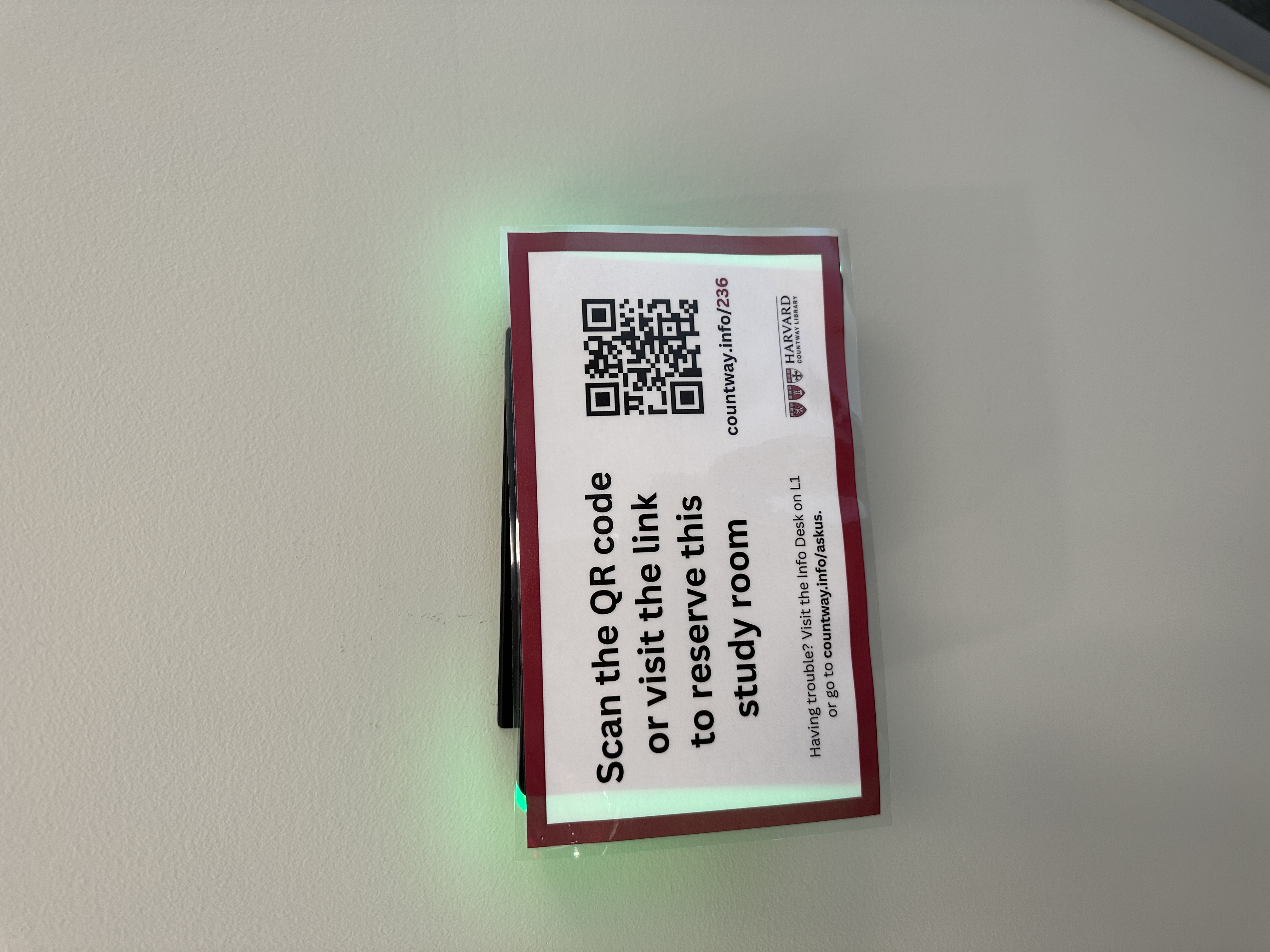 A sign on room 236 with a QR code and a URL to reserve it, alongside these instructions: Scan the QR code or visit the link to reserve this study room. Having trouble? Visit the Info Desk on L1 or go to countway.info/askus.