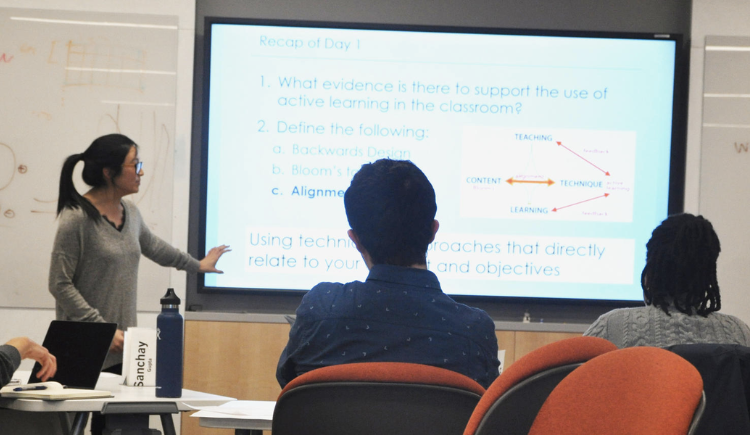 Women in front of a presentation screen talking to an audience