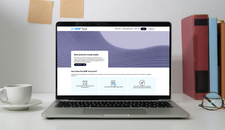 Laptop on desk showing the DMPTool landing page