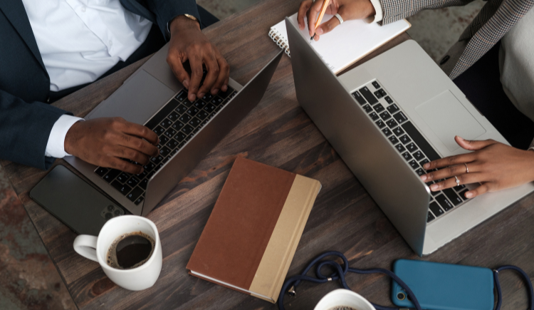 Two people on laptops in a meeting