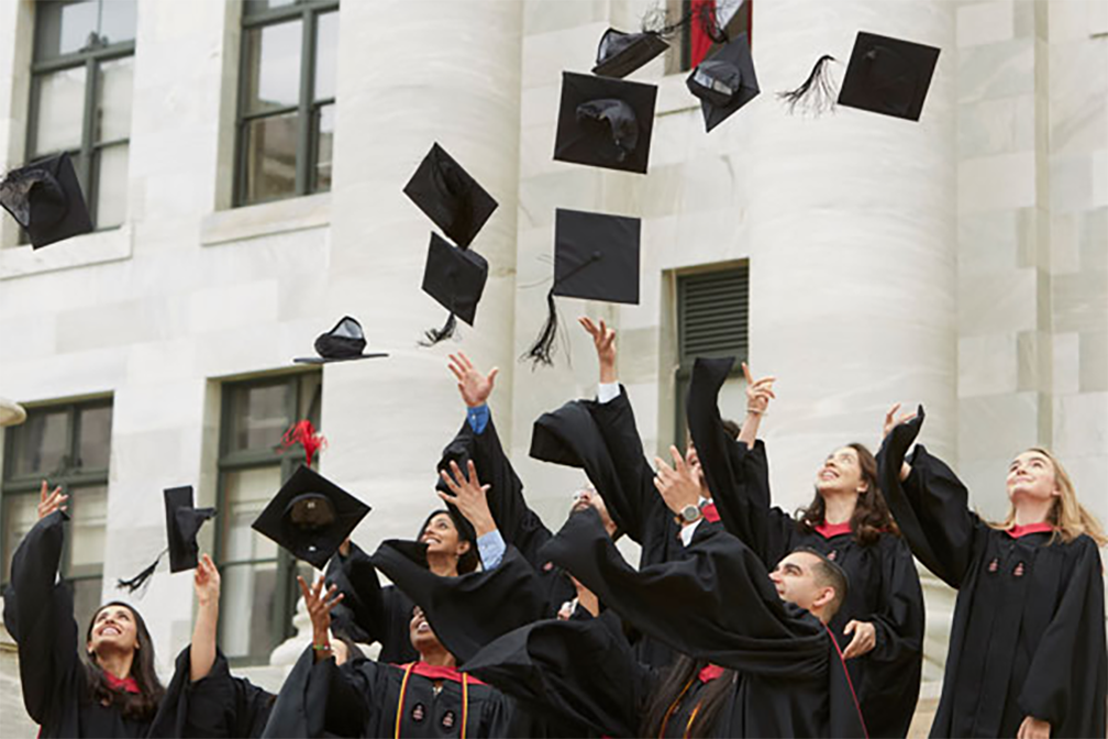 students throwing their graduation caps up in the air