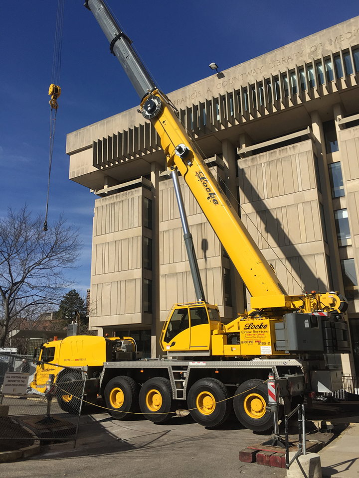 yellow construction truck in front of Countway Library